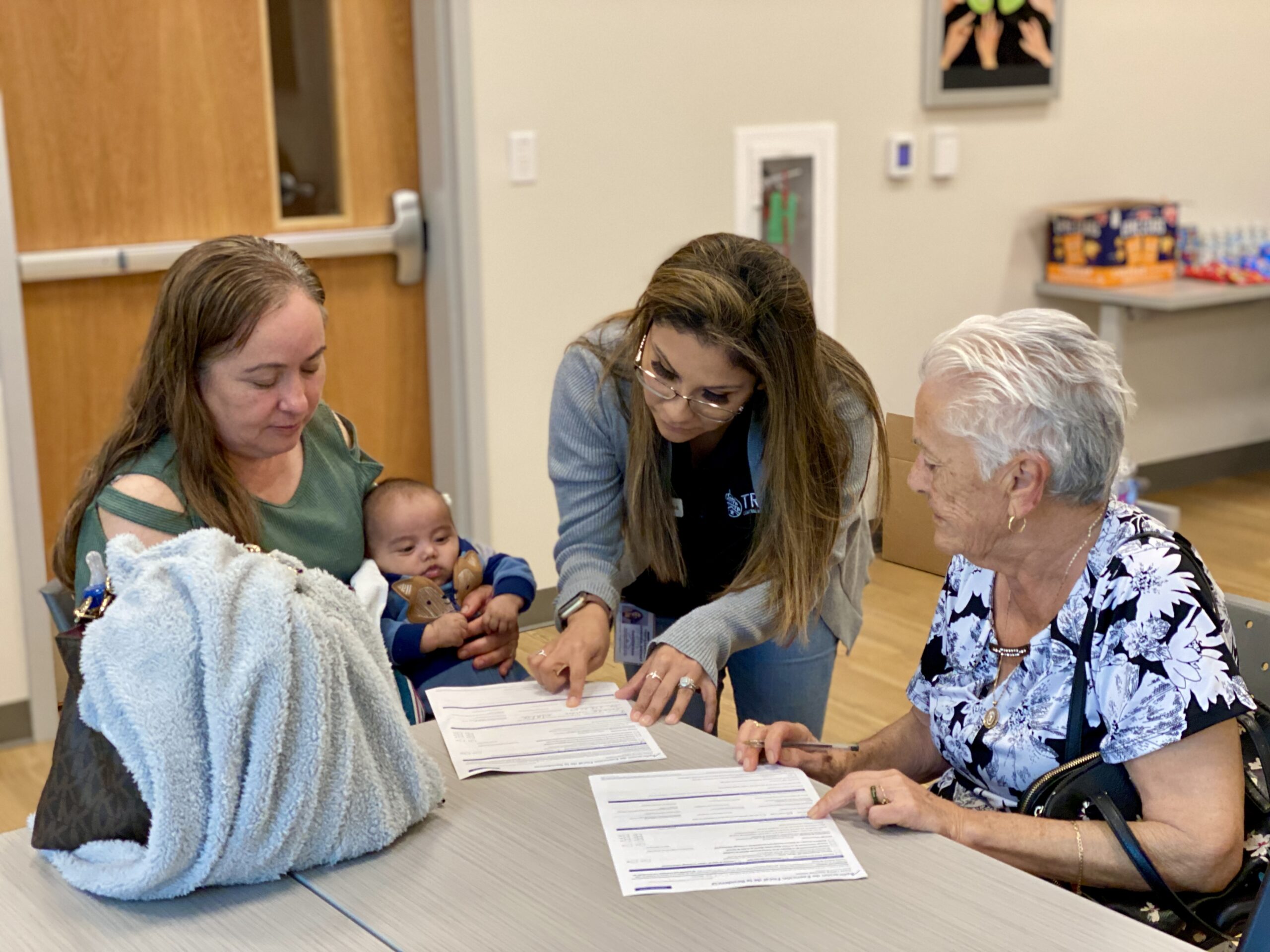 Staff member from the appraisal district helping two women with an application form